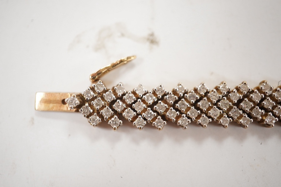 A modern 9ct gold and diamond cluster set bracelet, with arrow shaped links, 19.5cm, gross weight 25.2 grams. Condition - fair to good